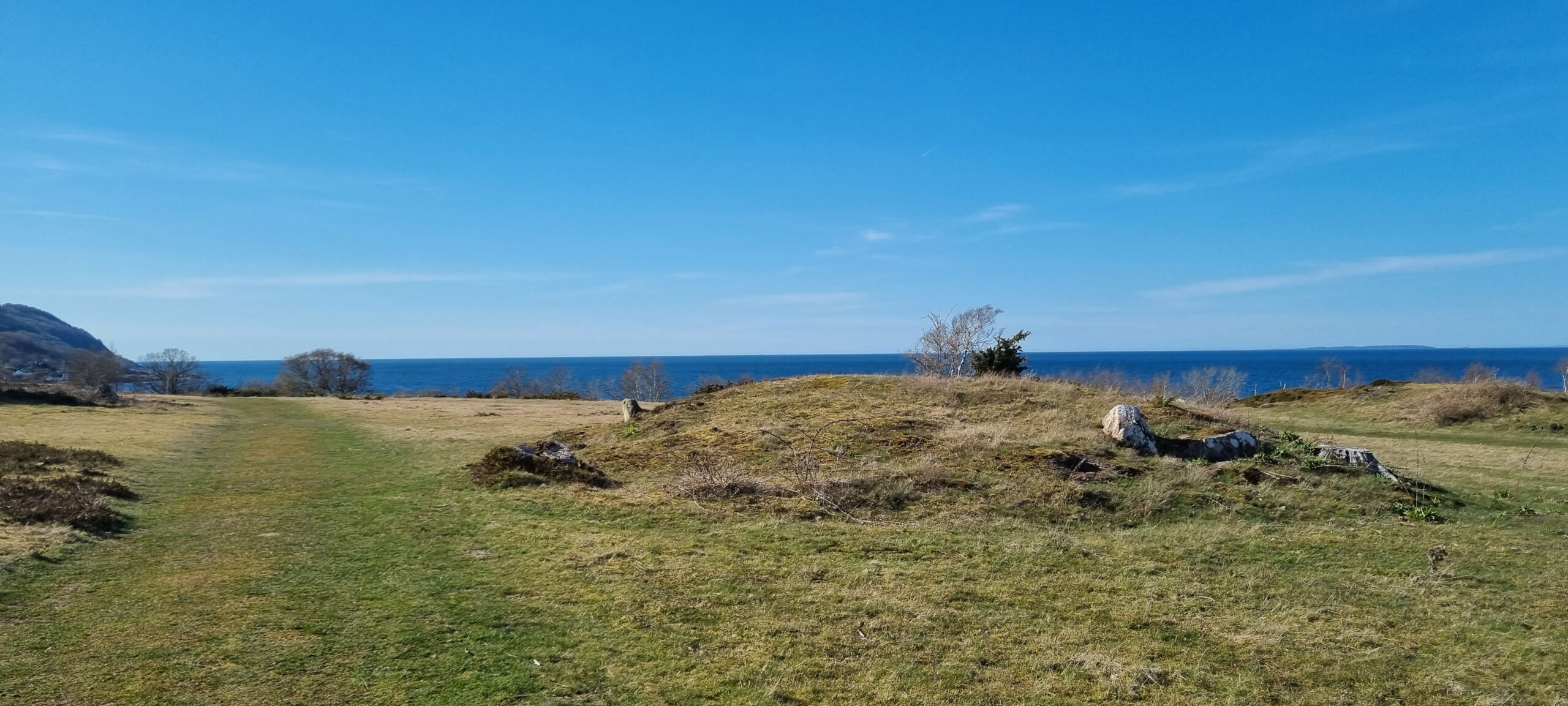 fäladsmark med hav och bronsåldersgrav